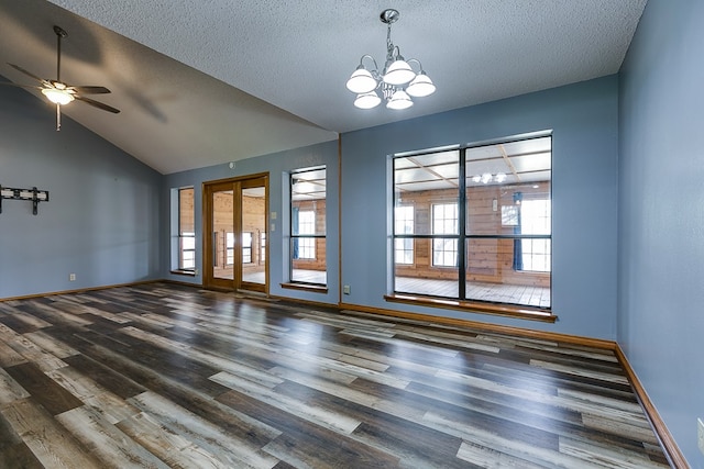 spare room with lofted ceiling, ceiling fan with notable chandelier, dark hardwood / wood-style flooring, and a textured ceiling