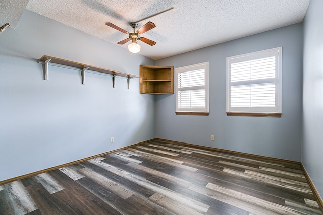 empty room featuring dark wood-type flooring, ceiling fan, lofted ceiling, and a textured ceiling