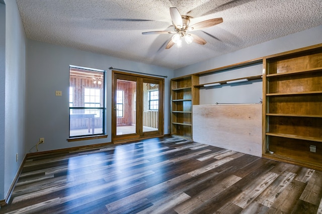 empty room with dark hardwood / wood-style flooring, ceiling fan, and a textured ceiling