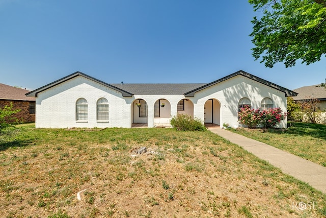 ranch-style house featuring a front lawn, brick siding, and a porch