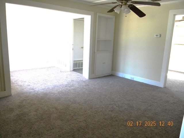 carpeted spare room with ceiling fan