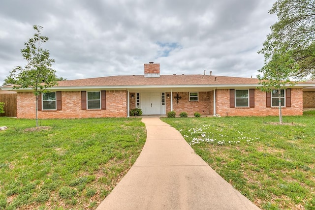 3305 Sierra Ct, San Angelo, TX 76904 - single story home with a chimney, a front lawn, and brick siding
