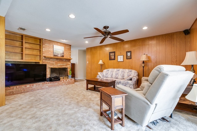 3305 Sierra Ct, San Angelo, TX 76904 - living area featuring wooden walls, ceiling fan, recessed lighting, a brick fireplace, and light colored carpet