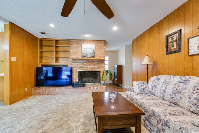 3305 Sierra Ct, San Angelo, TX 76904 - carpeted living room with wood walls, a ceiling fan, built in features, recessed lighting, and a fireplace
