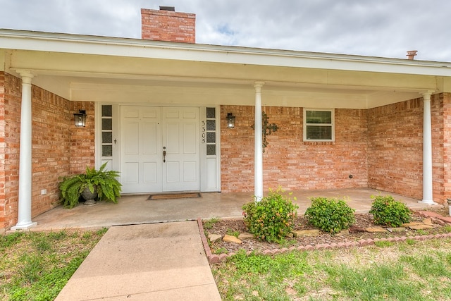 3305 Sierra Ct, San Angelo, TX 76904 - entrance to property featuring brick siding, a chimney, and covered porch