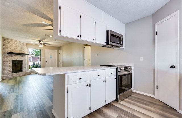 kitchen featuring white cabinets, stainless steel appliances, and a textured ceiling