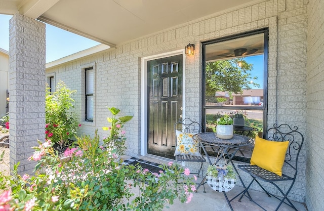 property entrance featuring brick siding and a porch