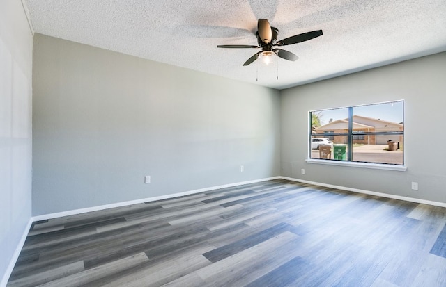 spare room with baseboards, wood finished floors, a textured ceiling, and ceiling fan