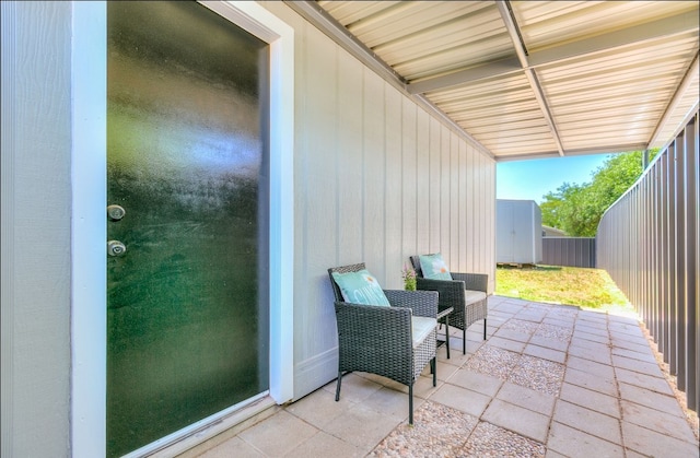 view of patio with fence, an outdoor structure, and a shed