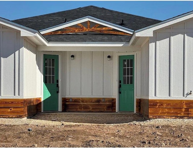 property entrance featuring board and batten siding and a shingled roof