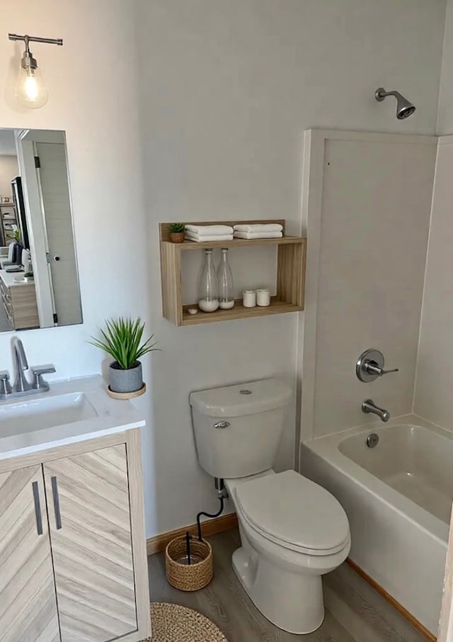 full bath featuring vanity, washtub / shower combination, toilet, and wood finished floors