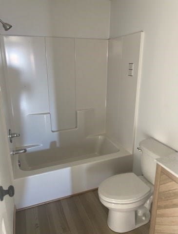 full bathroom featuring toilet, wood finished floors, and shower / bathtub combination