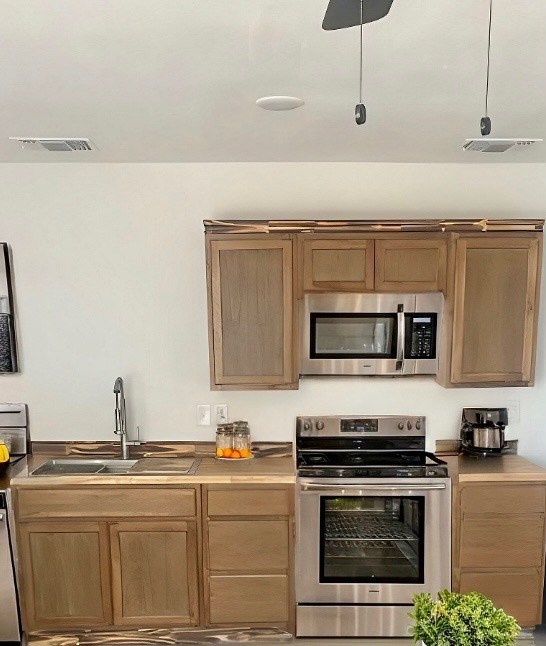 kitchen featuring visible vents, appliances with stainless steel finishes, and a sink