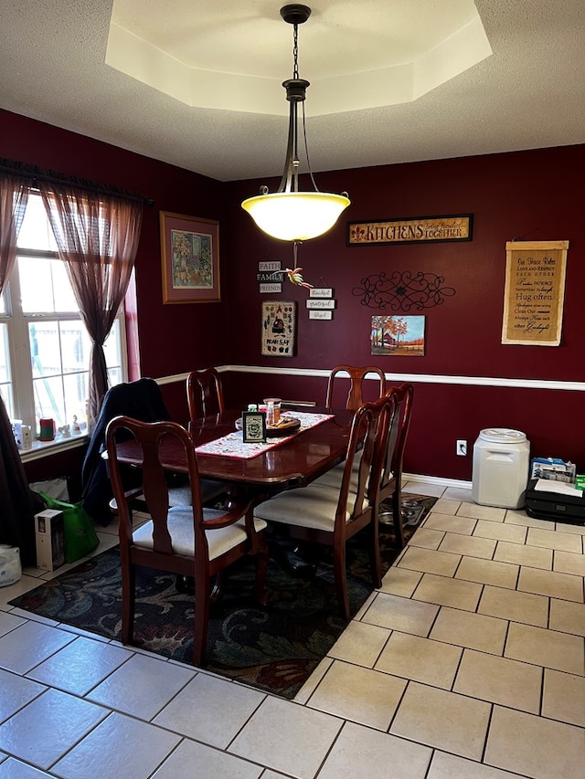 dining room featuring a textured ceiling and a tray ceiling