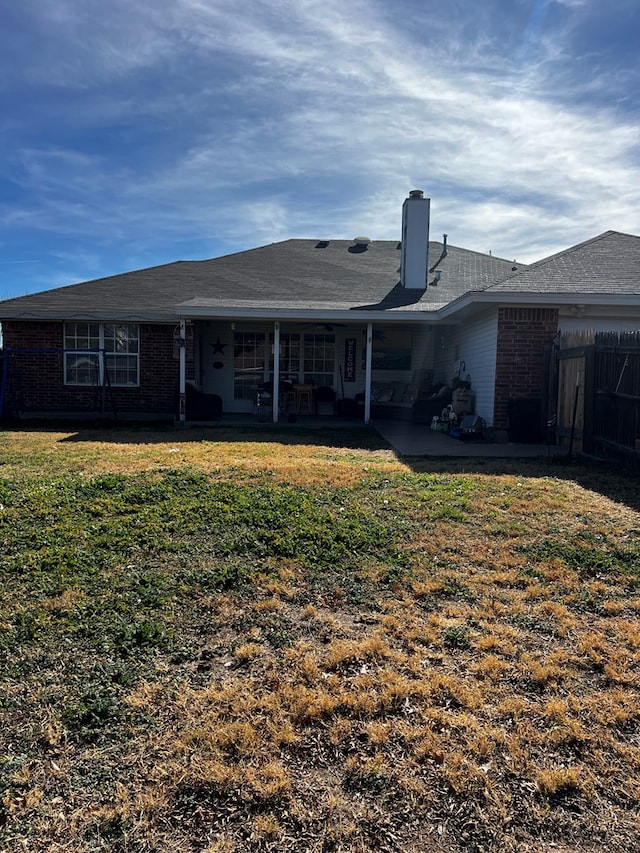 back of property featuring a patio area and a lawn