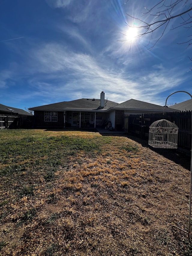 back of house featuring a lawn