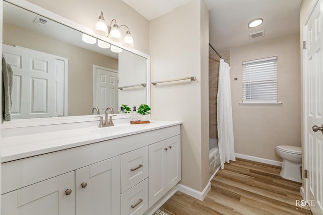 full bath with toilet, vanity, wood finished floors, baseboards, and shower / tub combo with curtain