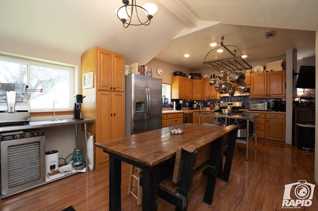 kitchen with stainless steel fridge, vaulted ceiling with beams, dark hardwood / wood-style floors, black dishwasher, and decorative backsplash