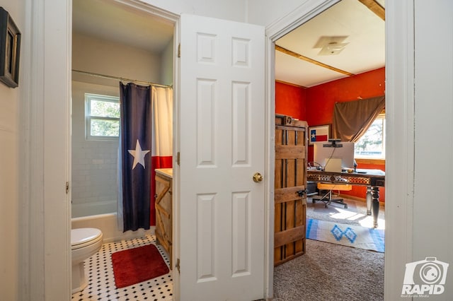 bathroom featuring shower / bathtub combination with curtain, a wealth of natural light, and toilet