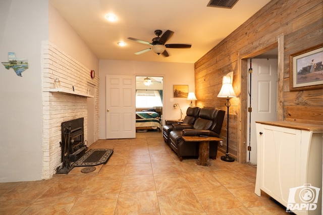 living room with ceiling fan and wooden walls