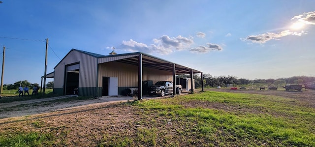 view of side of home featuring a garage and an outbuilding