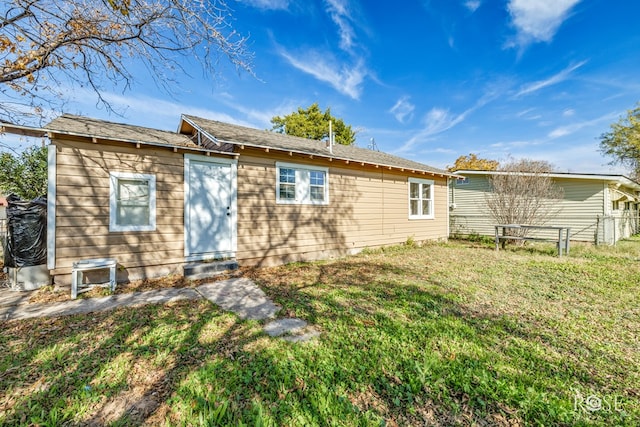 back of property featuring a lawn