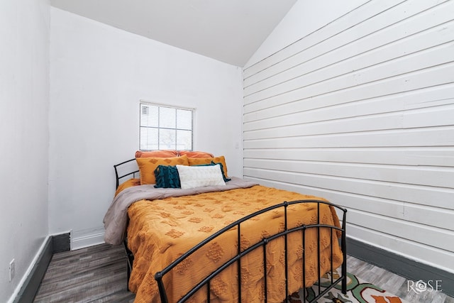 bedroom with lofted ceiling and dark hardwood / wood-style flooring