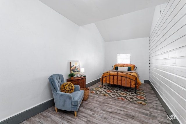 bedroom featuring hardwood / wood-style floors and vaulted ceiling