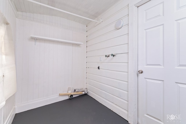 clothes washing area featuring wood walls