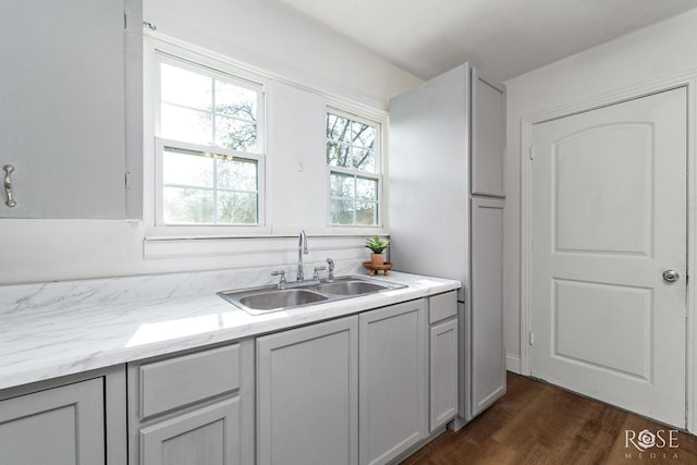 kitchen with sink, gray cabinetry, and dark hardwood / wood-style flooring