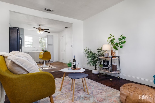 living room with ceiling fan, sink, and dark hardwood / wood-style flooring