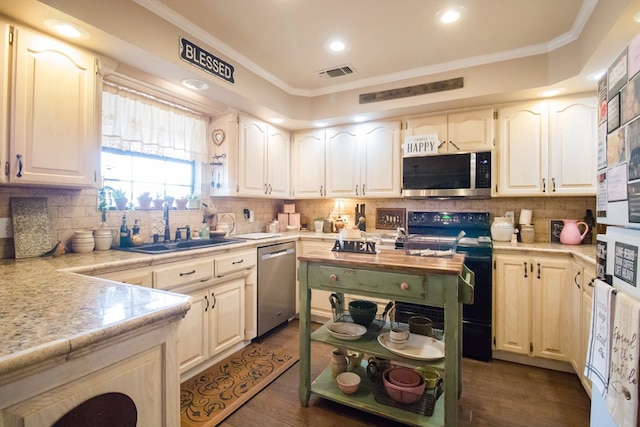 kitchen featuring appliances with stainless steel finishes, light countertops, a sink, and ornamental molding