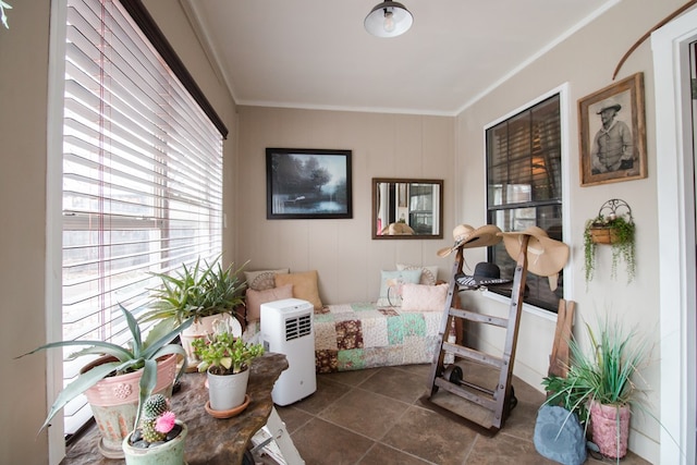 living area featuring crown molding and dark tile patterned floors