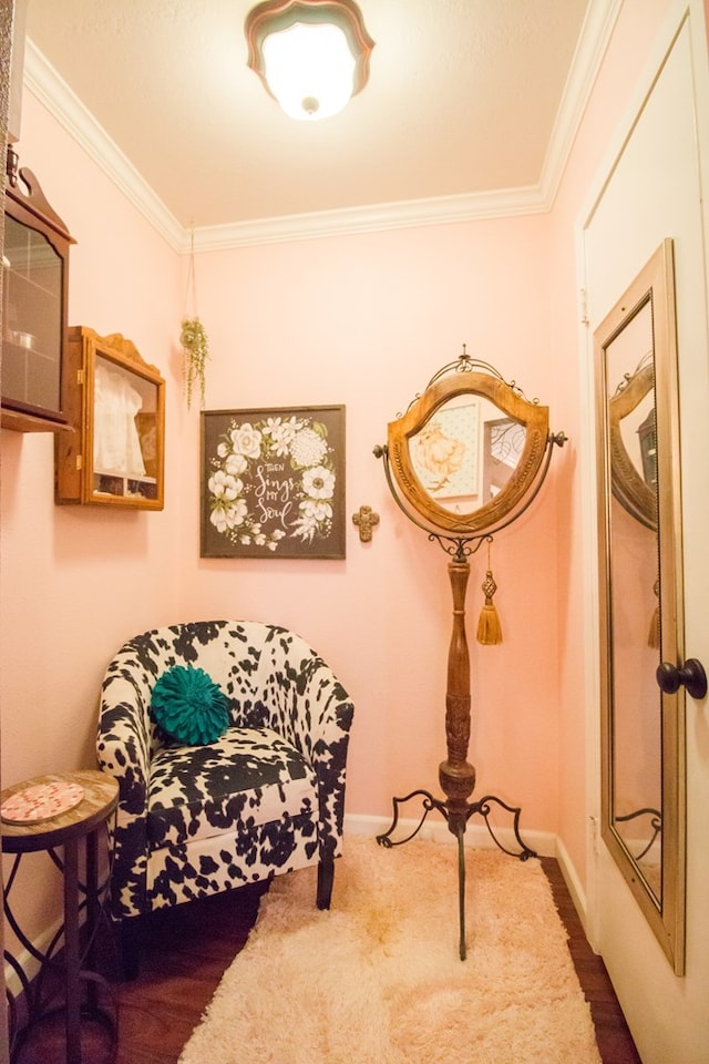 living area with baseboards, dark carpet, and crown molding