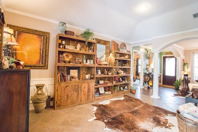 sitting room featuring ornate columns, light tile patterned floors, arched walkways, and crown molding