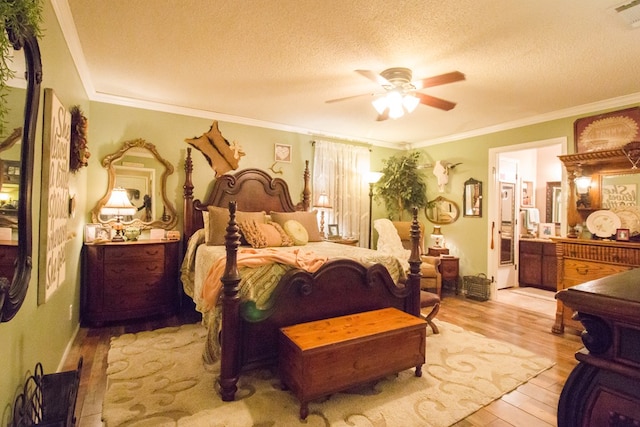 bedroom with a textured ceiling, ceiling fan, light wood-style flooring, visible vents, and ornamental molding