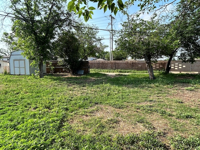 view of yard featuring an outbuilding, a storage unit, and a fenced backyard
