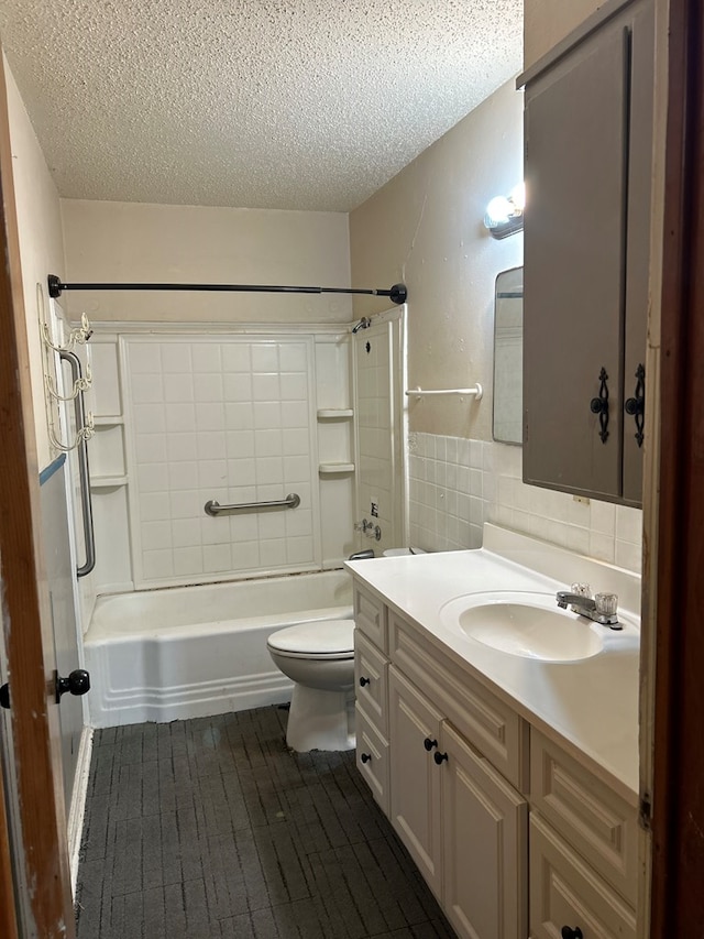 full bath with tile walls, toilet, vanity, washtub / shower combination, and a textured ceiling
