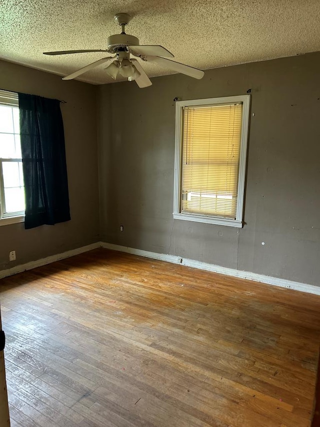 empty room featuring a textured ceiling, ceiling fan, and hardwood / wood-style floors