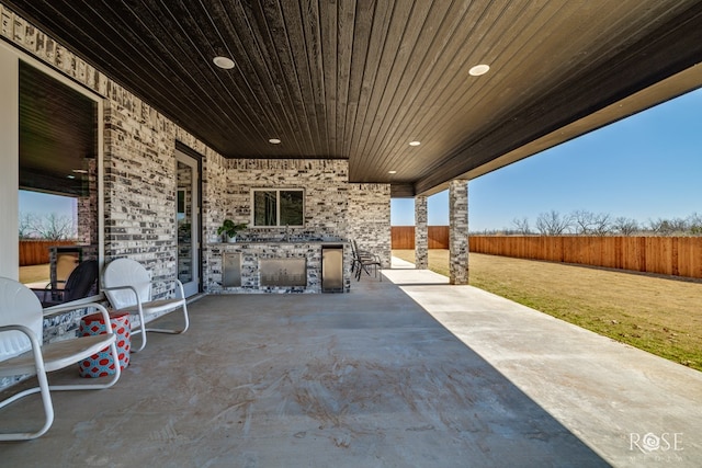 view of patio featuring exterior kitchen and a fenced backyard