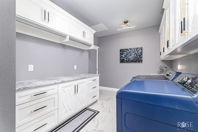 laundry area featuring marble finish floor, washing machine and dryer, cabinet space, and baseboards