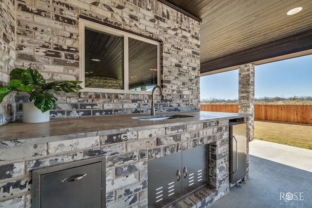 view of patio featuring a sink and fence