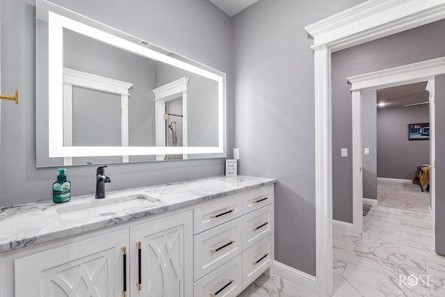 bathroom featuring marble finish floor, vanity, and baseboards