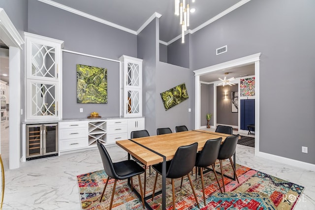 dining space with marble finish floor, a dry bar, ornamental molding, beverage cooler, and baseboards