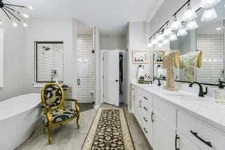 bathroom with vanity, a chandelier, and separate shower and tub