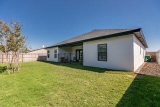 back of property featuring a lawn