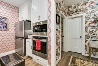 kitchen with white cabinetry, appliances with stainless steel finishes, and light wood-type flooring