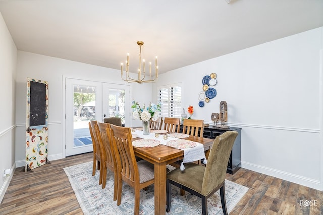 dining space featuring french doors, dark hardwood / wood-style flooring, and a chandelier