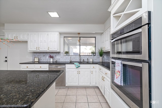 kitchen with sink, white cabinetry, decorative light fixtures, light tile patterned floors, and appliances with stainless steel finishes