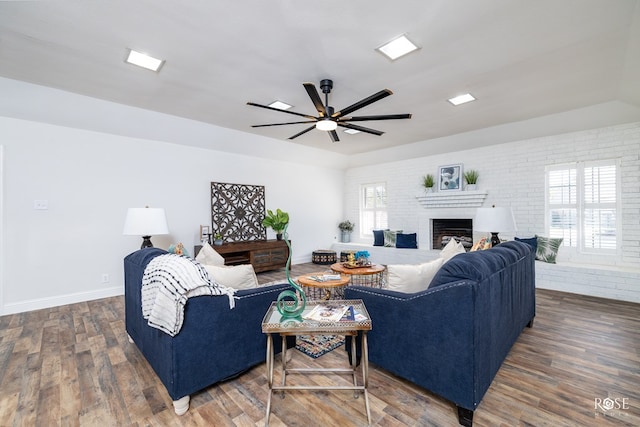 living room featuring ceiling fan, brick wall, and dark hardwood / wood-style flooring